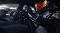 a man driving a race car with a helmet on